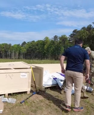Workers unloading a compact packaged tank system from crates at an outdoor installation site. Workers unloading a compact packaged tank system from crates at an outdoor installation site.