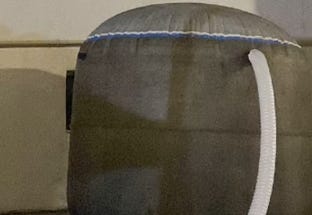 Indoor dome-shaped water tank connected to a hose for cooling or water storage. Indoor dome-shaped water tank connected to a hose for cooling or water storage.