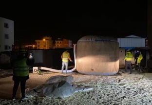 Night installation of large water tank by crew. Night installation of large water tank by crew.