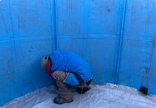 Worker inside tank during setup. Worker inside tank during setup.