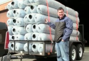 Man standing beside a trailer loaded with stacked EZflow drainfield bundles for gravel-free septic system installation. Man standing beside a trailer loaded with stacked EZflow drainfield bundles for gravel-free septic system installation.