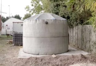 Outdoor water tank on concrete pad in yard. Outdoor water tank on concrete pad in yard.