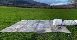 Foundation liner laid out on grass with rolled tank material ready for installation. Foundation liner laid out on grass with rolled tank material ready for installation.