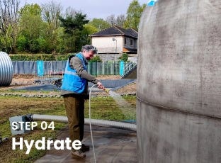 Worker spraying water on an inflatable concrete tank during Step 04: Hydrate of the installation process. Worker spraying water on an inflatable concrete tank during Step 04: Hydrate of the installation process.